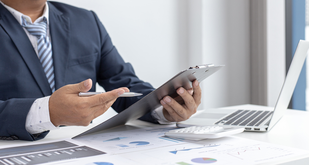 Businessman Looking at Clipboard 